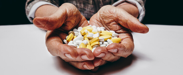 person holding multi colored pills in hands