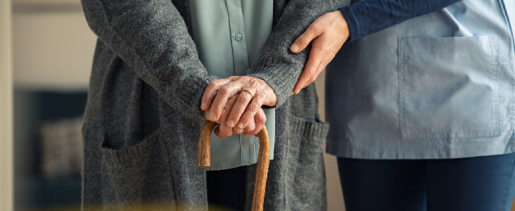 nure holding elderly person with cane nursing home neglicance