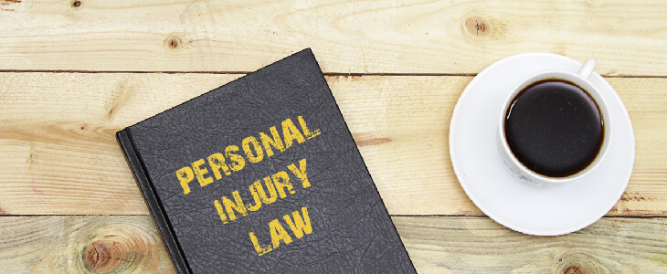 personal injury law book on a table with a cup of coffee